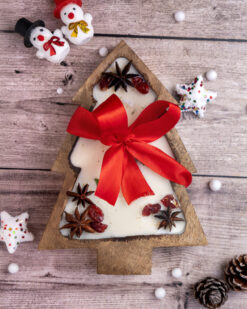 Christmas tree candle in a wooden bowl, adorned with cranberries and greenery, perfect for cozy holiday decor.