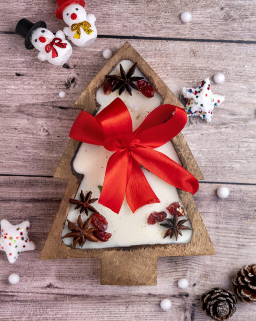 Christmas tree candle in a wooden bowl, adorned with cranberries and greenery, perfect for cozy holiday decor.